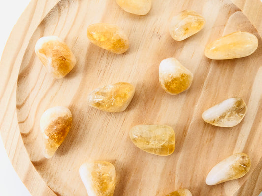 Piedra de citrino natural de forma rodada y canto pulido, mostrando tonalidades amarillas doradas y zonas transparentes que captan la luz