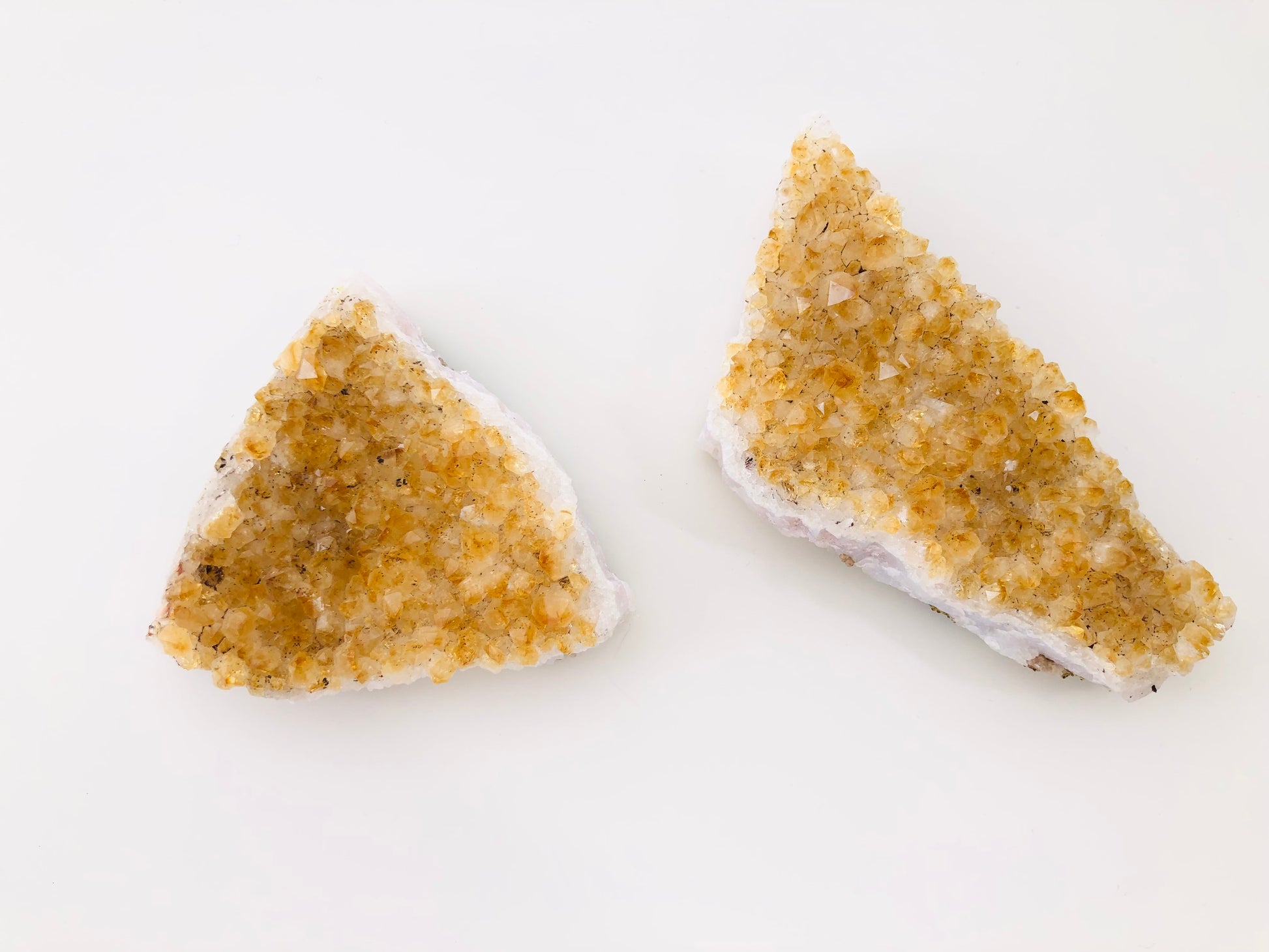 drusas de citrino natural con cristales en tonos amarillos y anaranjados brillantes sobre base de roca.