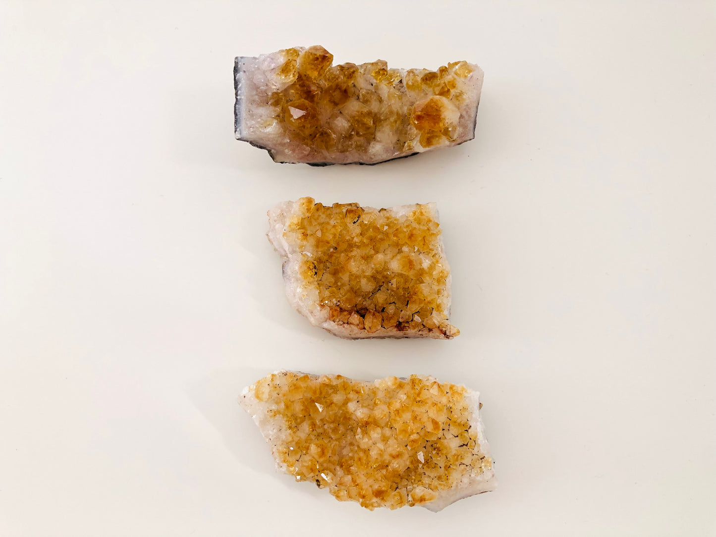 Set de tres piedras de citrino en bruto tipo drusa mostrando su estructura cristalina natural.