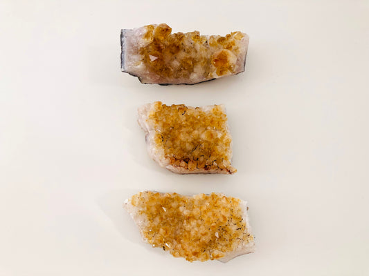 Set de tres piedras de citrino en bruto tipo drusa mostrando su estructura cristalina natural.