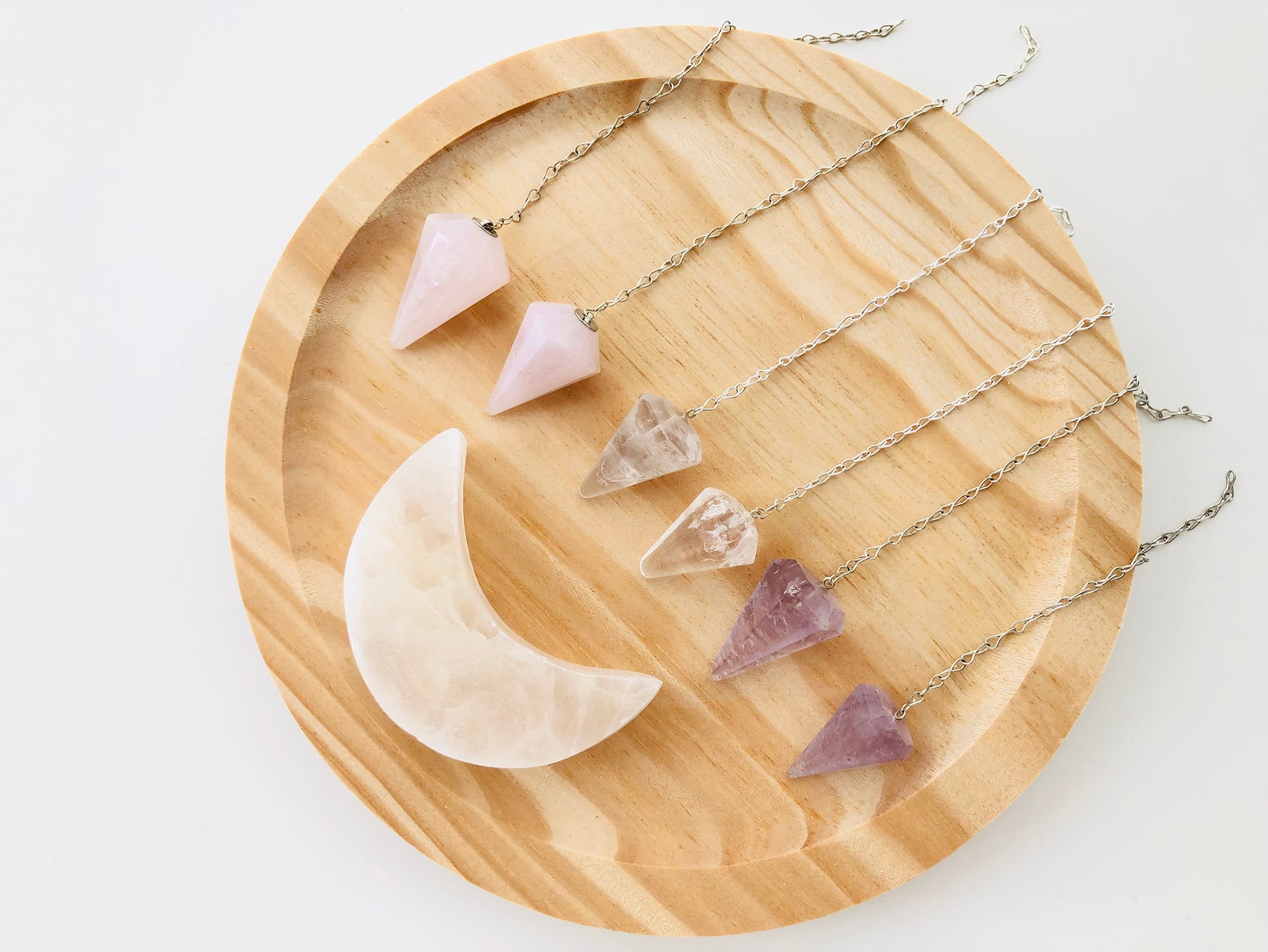 Conjunto de péndulos minerales de amatista, cuarzo rosa y citrino facetados para terapias energéticas.