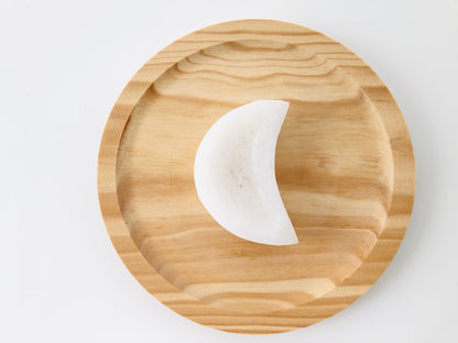 Cuenco de piedra selenita blanca en forma de luna creciente utilizado para la limpieza energética de piedras preciosas y recarga de cuarzos.