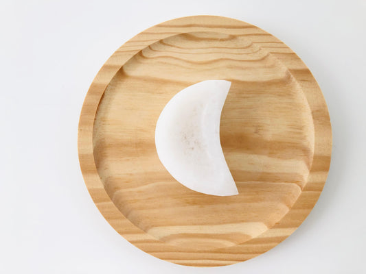 Cuenco de piedra selenita blanca en forma de luna creciente utilizado para la limpieza energética de piedras preciosas y recarga de cuarzos.