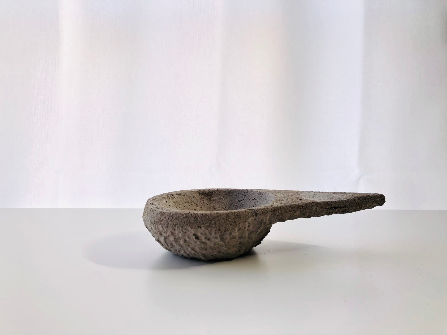 Sahumador triangular de cemento gris de la marca Sagrada Madre, diseñado para rituales de limpieza con un estilo moderno y minimalista.