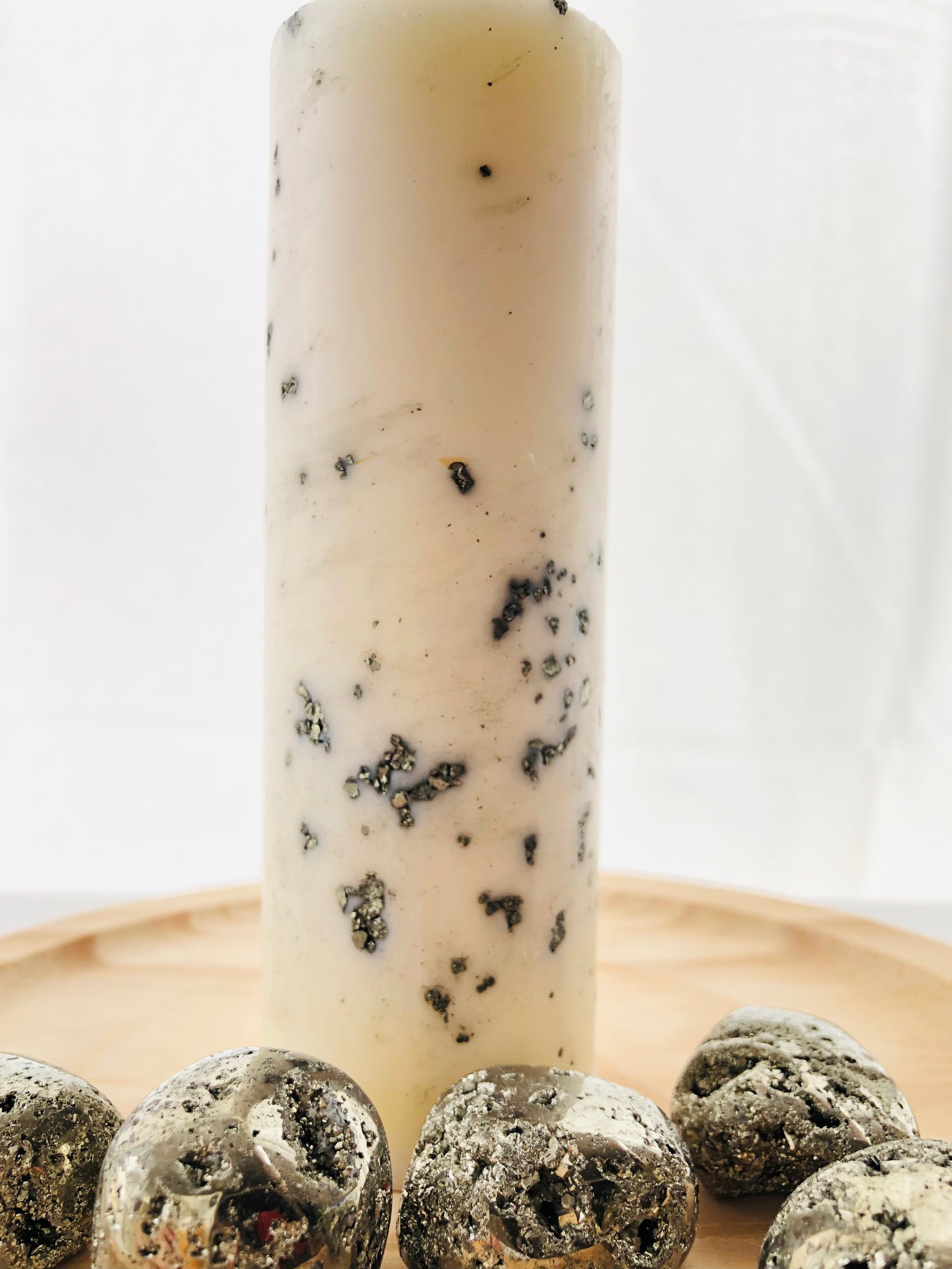 Vela esotérica amarilla con pepitas de piedra pirita natural, diseñada para rituales de atracción de dinero y éxito económico.