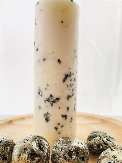Vela esotérica amarilla con pepitas de piedra pirita natural, diseñada para rituales de atracción de dinero y éxito económico.