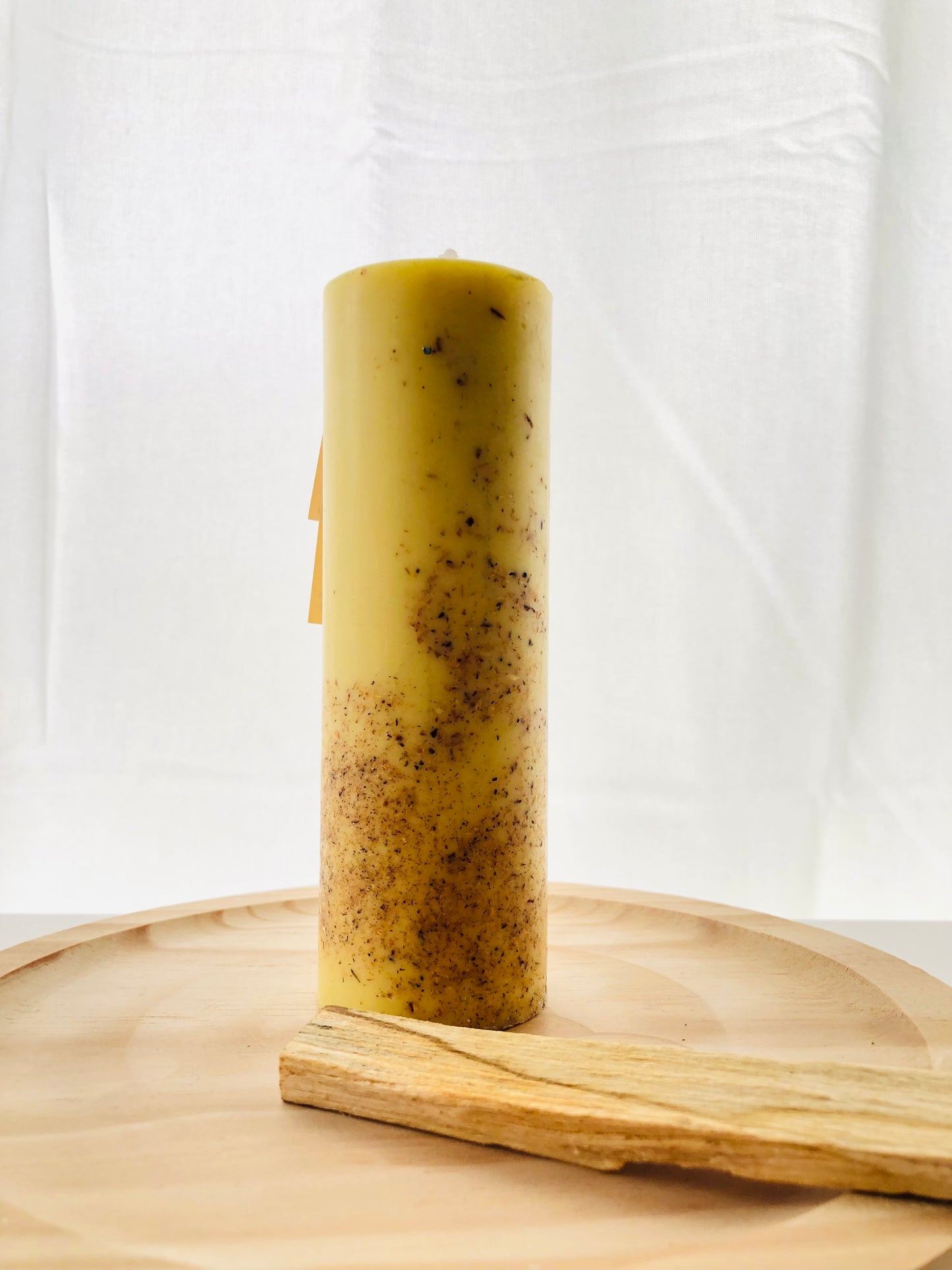 Vela esotérica de Palo Santo encendida sobre un altar de madera, rodeada de cristales naturales para un ritual de purificación energética.