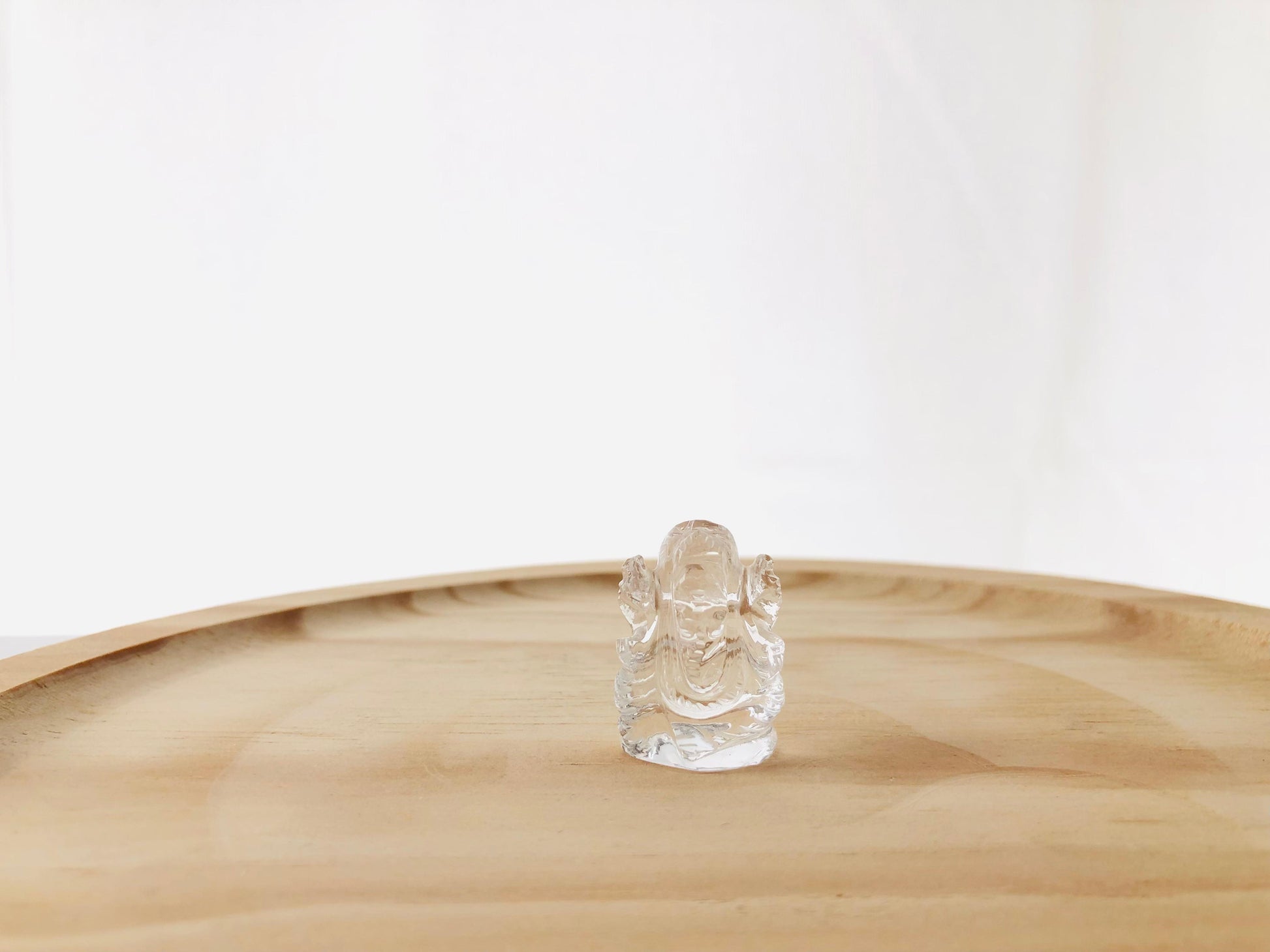 Estatua artesanal de Ganesha tallada en cuarzo cristal transparente, detalle decorativo de deidad hindú para el hogar.
