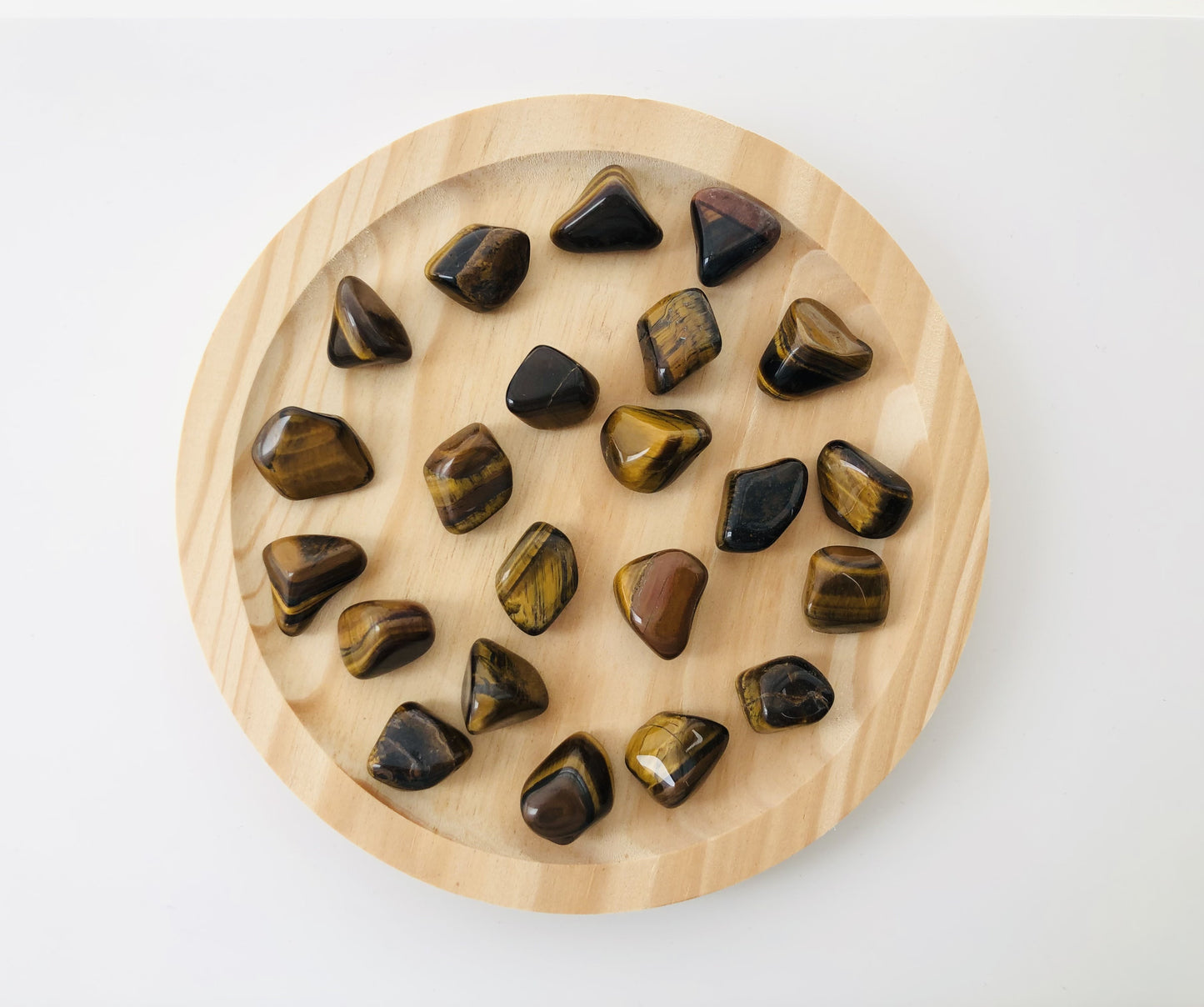 Piedra de ojo de tigre rodada utilizada como amuleto de protección y confianza, mineral natural con veteado dorado pulido para llevar como piedra de bolsillo.