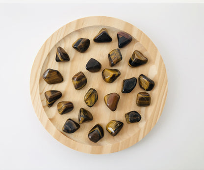 Piedra de ojo de tigre rodada utilizada como amuleto de protección y confianza, mineral natural con veteado dorado pulido para llevar como piedra de bolsillo.