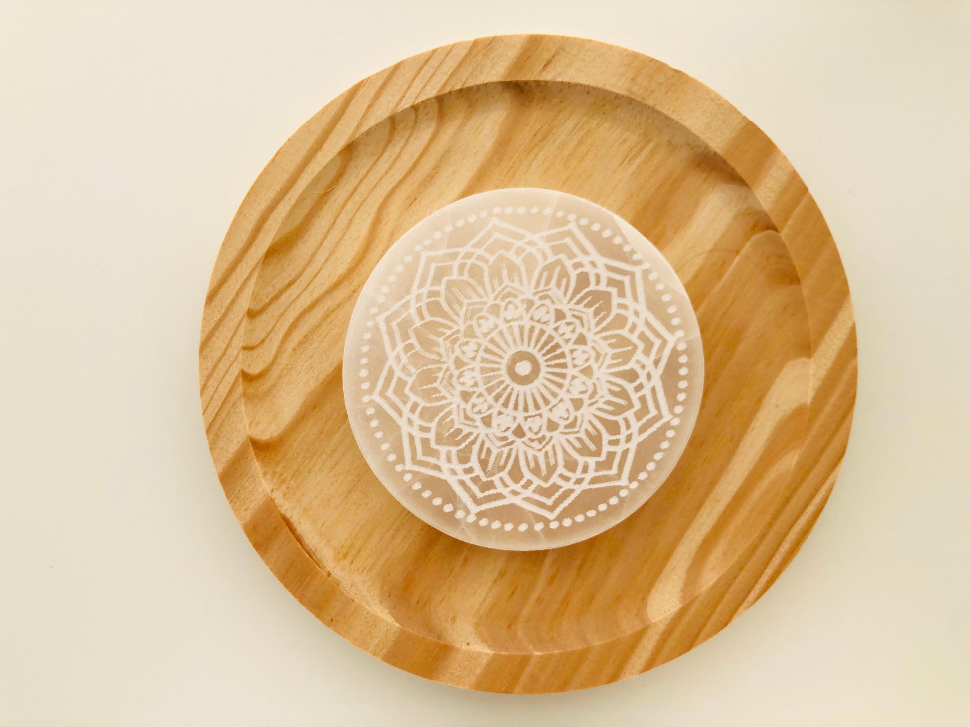 Base de selenita natural con grabado de mandala para armonización de espacios y limpieza profunda de minerales y piedras energéticas.
