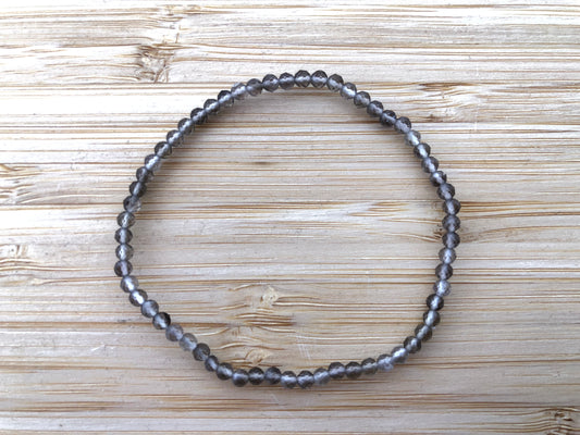 Pulsera de cuentas de cuarzo ahumado con corte facetado que refleja la luz, mostrando tonos marrones translúcidos y un diseño elegante de joyería fina