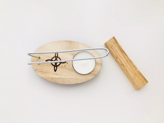 Quemador de palo santo fabricado en madera natural con un diseño de soporte circular y un orificio central para sujetar el palito de incienso, mostrando vetas naturales y un acabado artesanal.