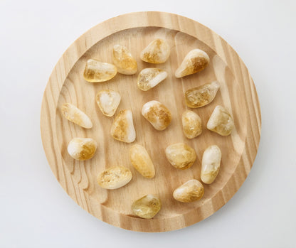 Piedra de citrino de color amarillo brillante y forma redondeada, con una superficie pulida que muestra una claridad cristalina y reflejos dorados bajo la luz.