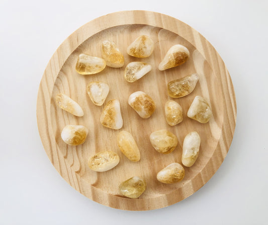 Piedra de citrino de color amarillo brillante y forma redondeada, con una superficie pulida que muestra una claridad cristalina y reflejos dorados bajo la luz.