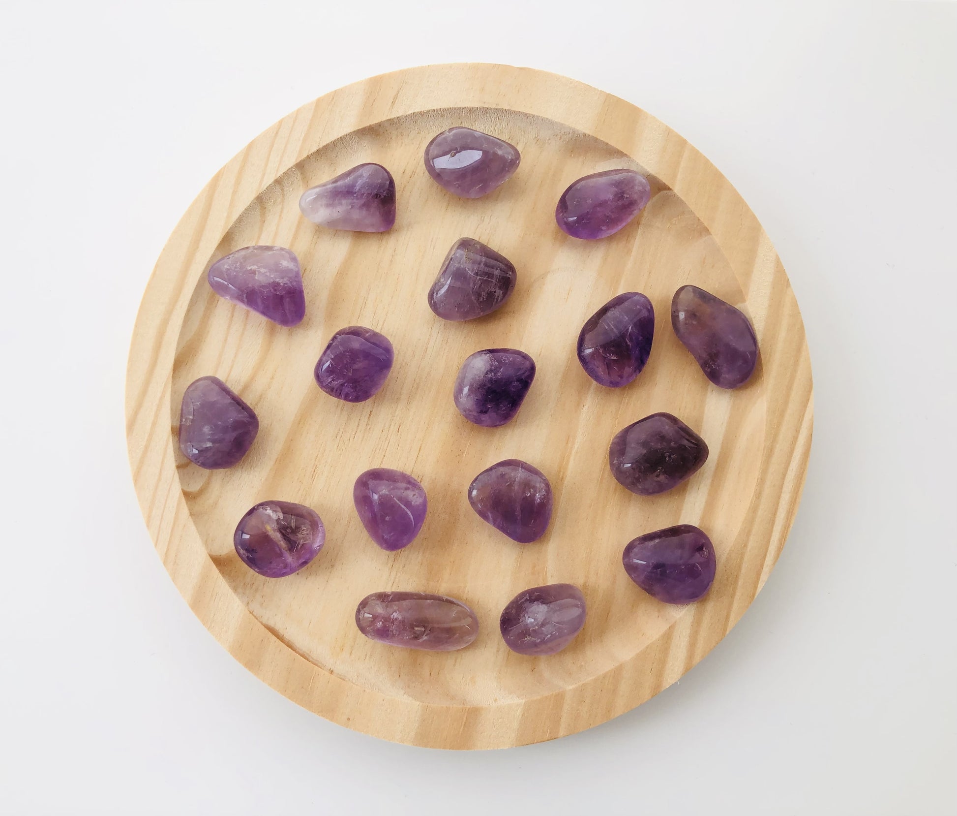 Varios rodados de amatista natural de color violeta con acabados pulidos y brillantes, mostrando diferentes intensidades de morado y vetas cristalinas internas.