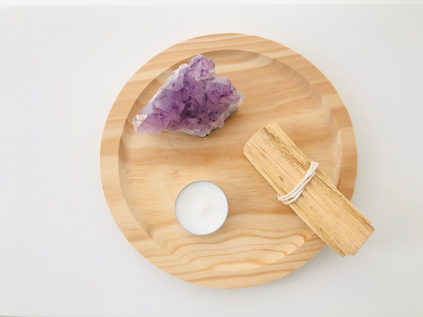 Trozo de madera natural de palo santo con corte rústico y fibras visibles, mostrando tonos cremosos y amarillentos típicos de esta madera sagrada.