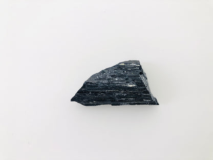 Turmalina negra catedral en bruto, piedra natural de alta calidad para coleccionistas de minerales, caracterizada por su estructura cristalina estriada y color negro puro.