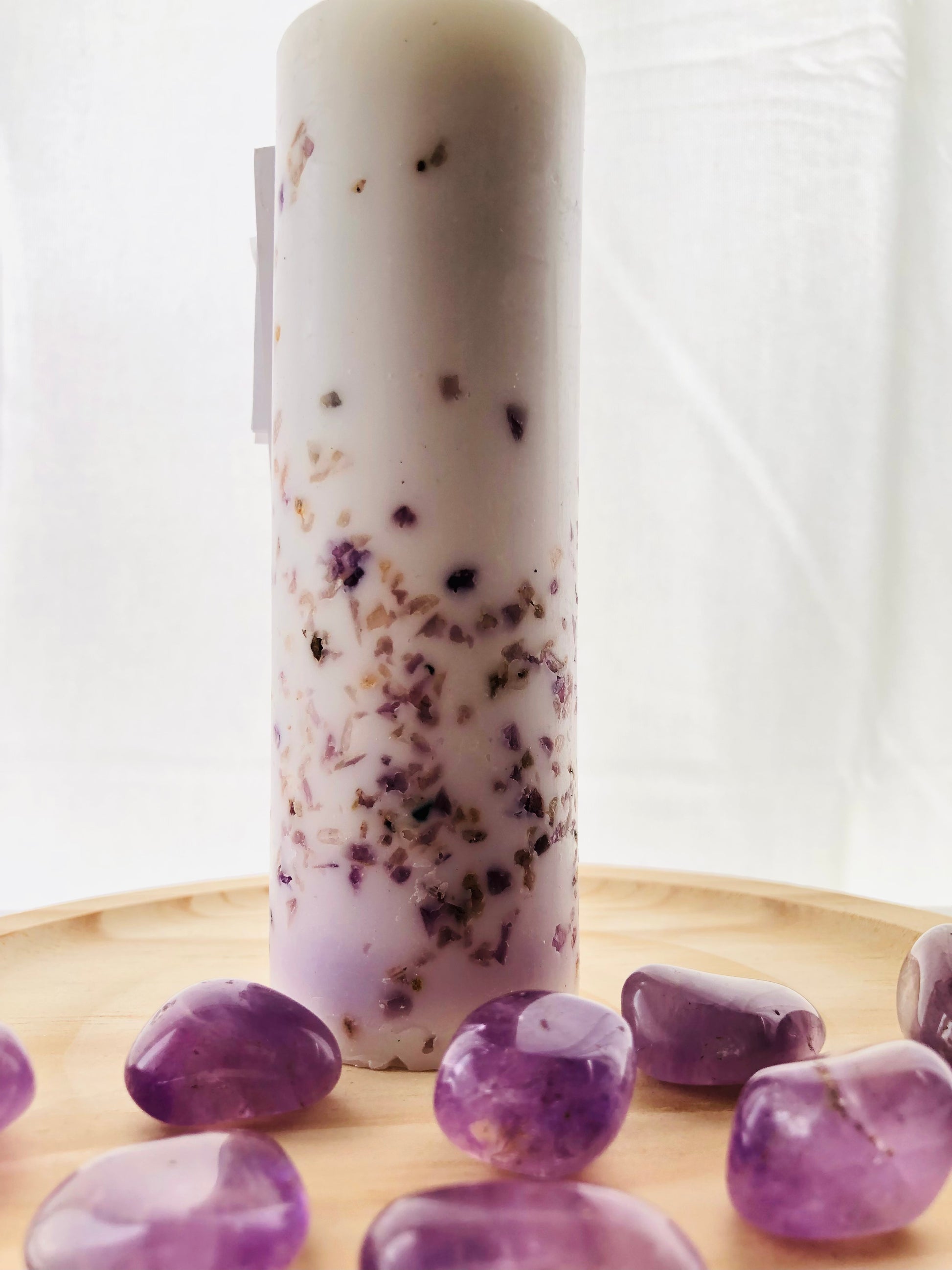 Vela aromática esotérica con piedras de amatista natural sobre una mesita de noche, aportando una estética zen y relajante al dormitorio.